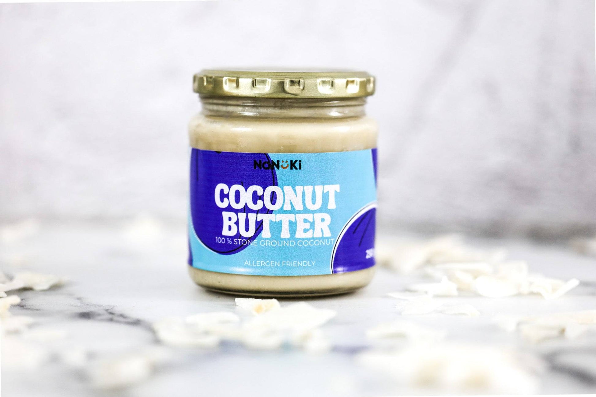 Coconut Butter in a glass jar with blue label, made from 100% stone ground coconut. Vegan, gluten-free, and allergen-friendly spread.